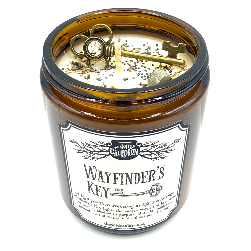 Wayfinder’s Key ritual candle with key, pyrite, wormwood, vervain and poppy seeds for doorway and crossroads magic by The Wild Cauldron.